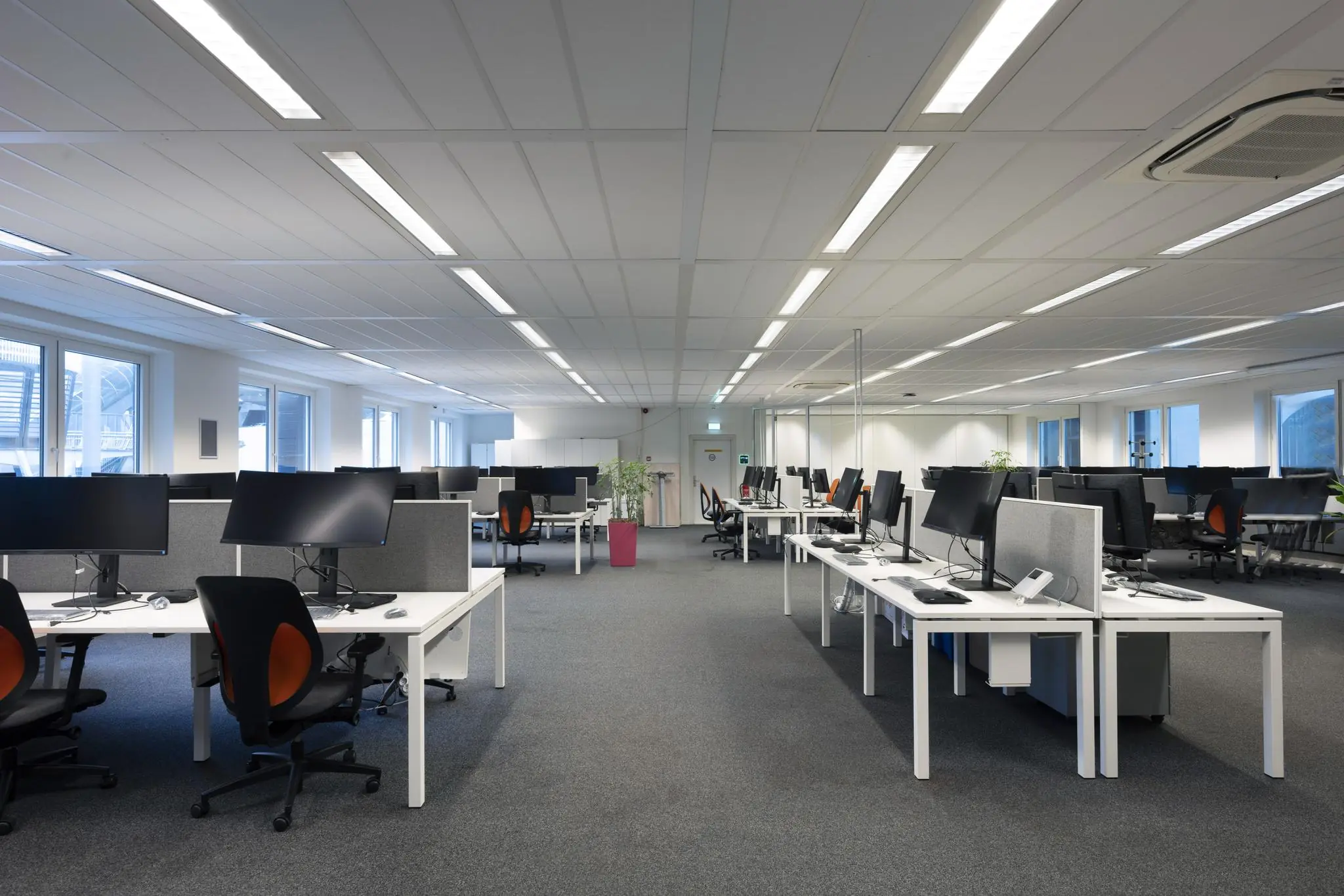 Moderne, ruime kantoortuin met werkplekken en computerschermen aan de Johan Cruijff Boulevard.